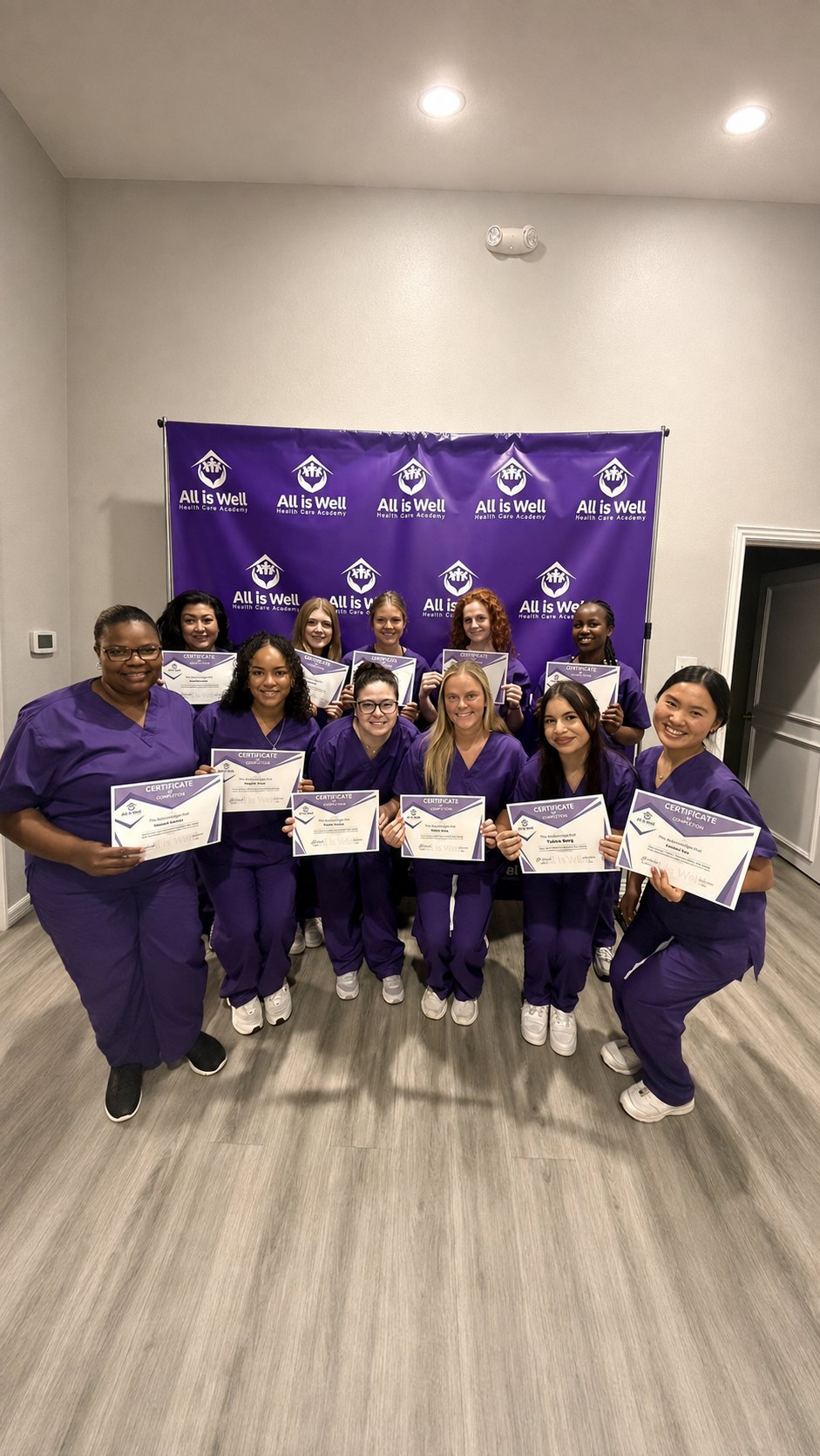 An All is Well Health Care Academy graduating class holding their certificates