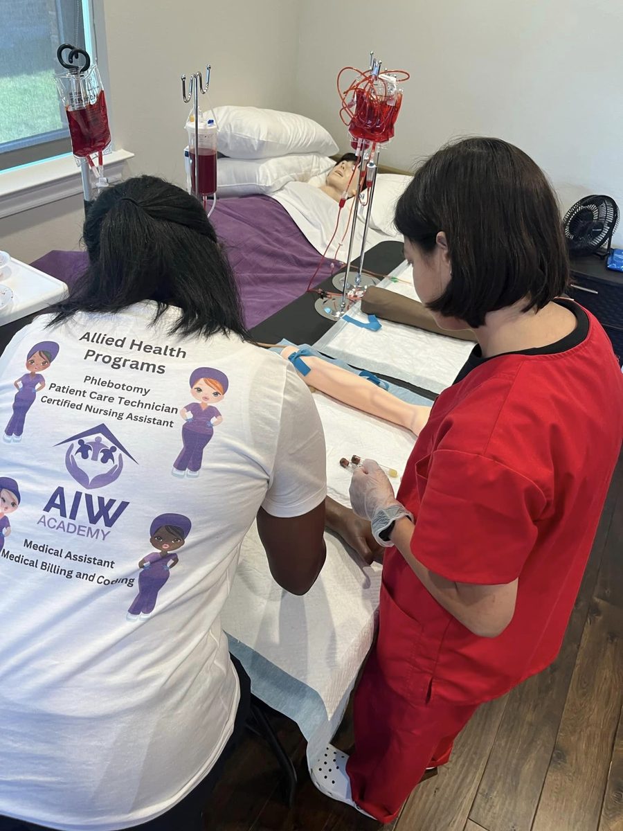 Student in All is Well shirt practising bedside care