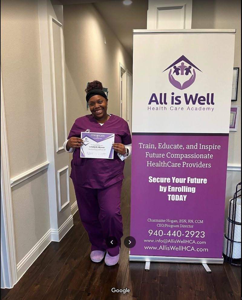 Graduate in purple scrubs with certificate