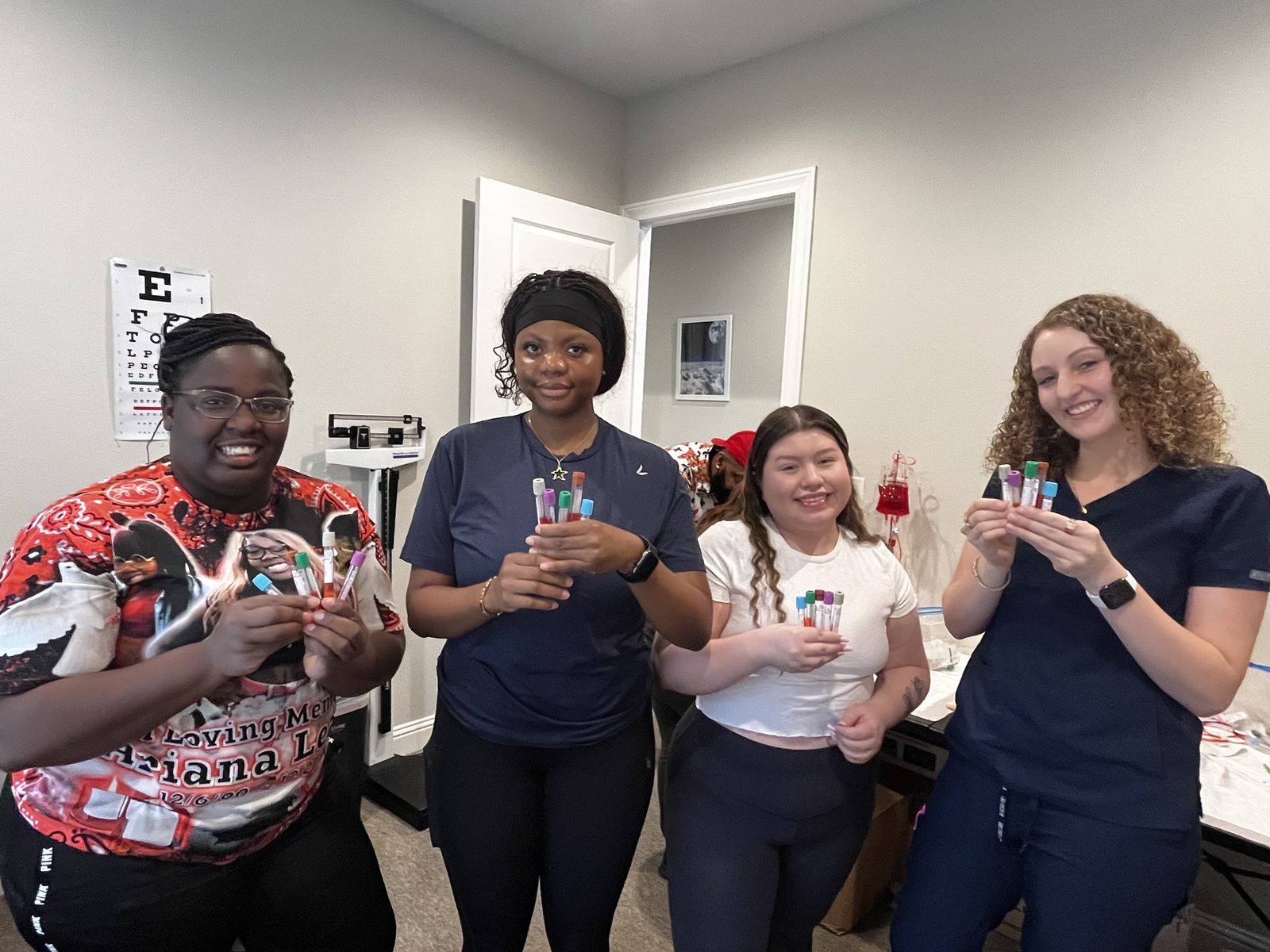 Phlebotomy students practising with collection tubes in the skills room