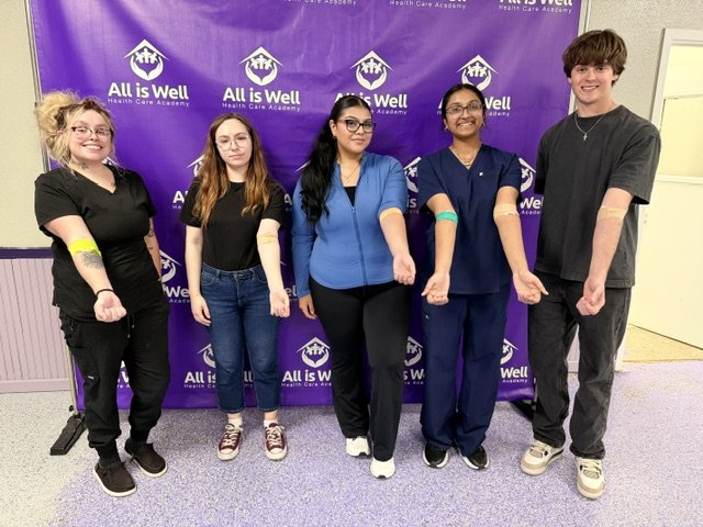 Five phlebotomy students showing bandaged arms after practising live draws
